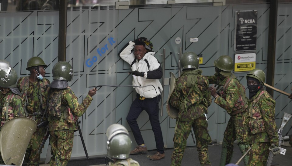 Politiet omringer en demonstrant i Nairobi.